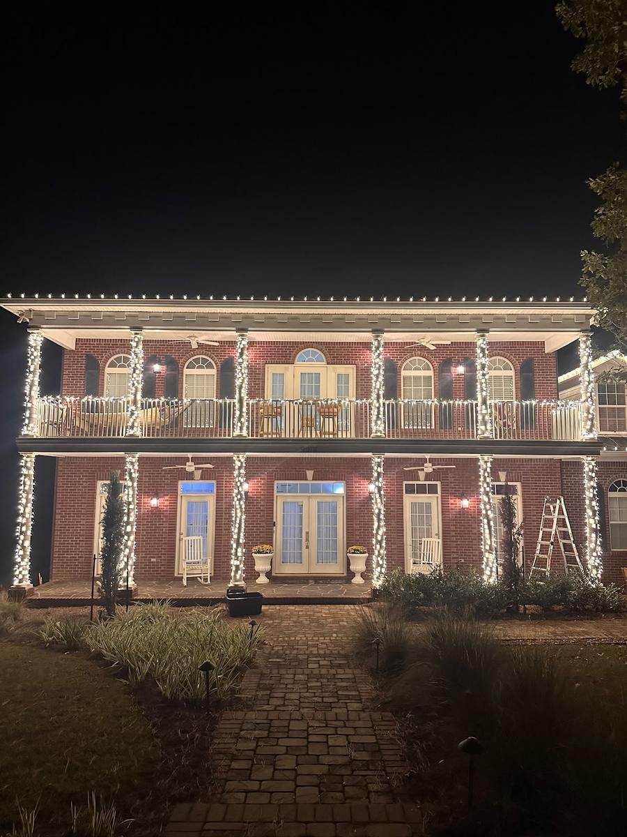 Two-story porch home with lit columns and roofline