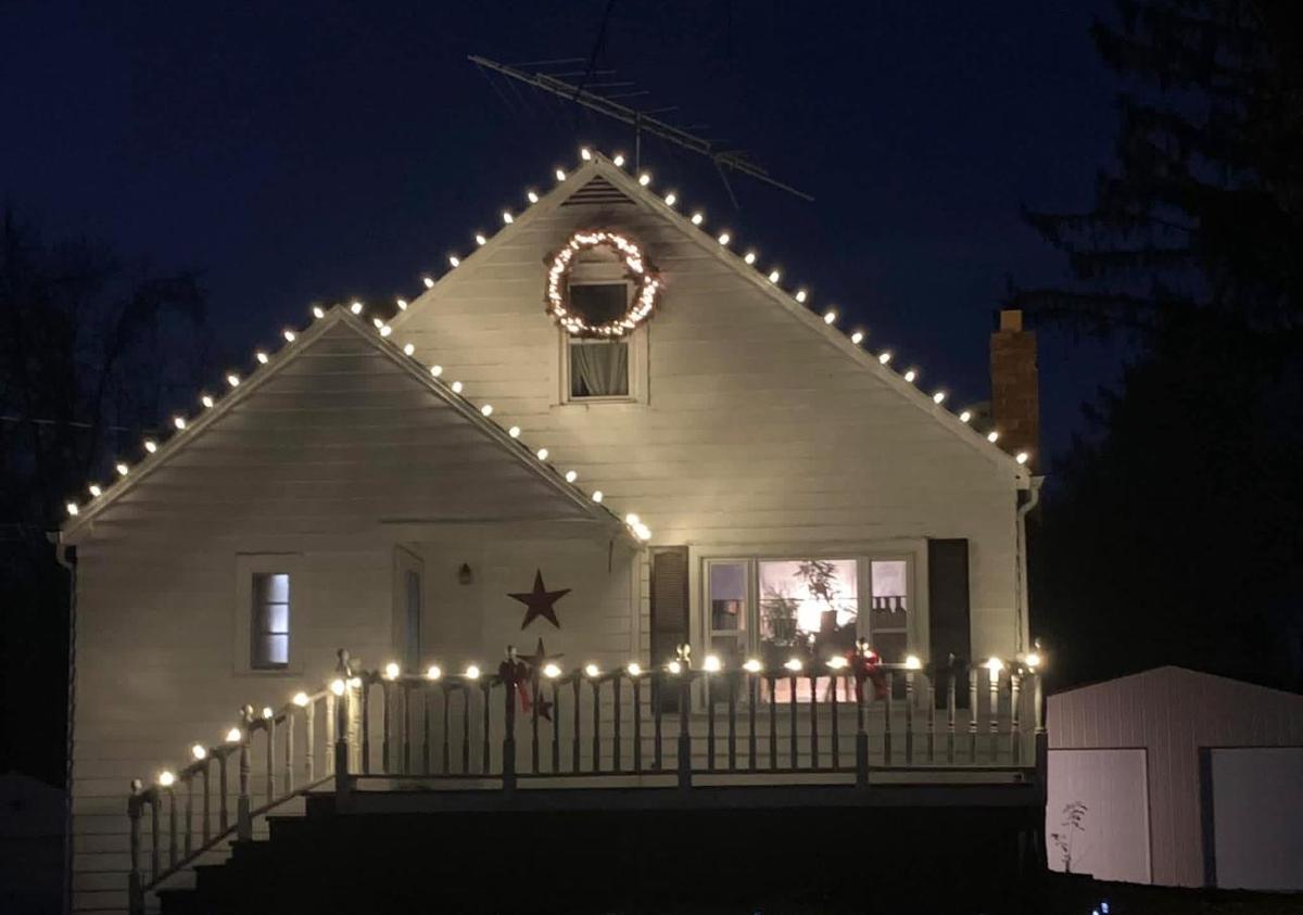 Cape Cod home with roofline lights and a lit wreath