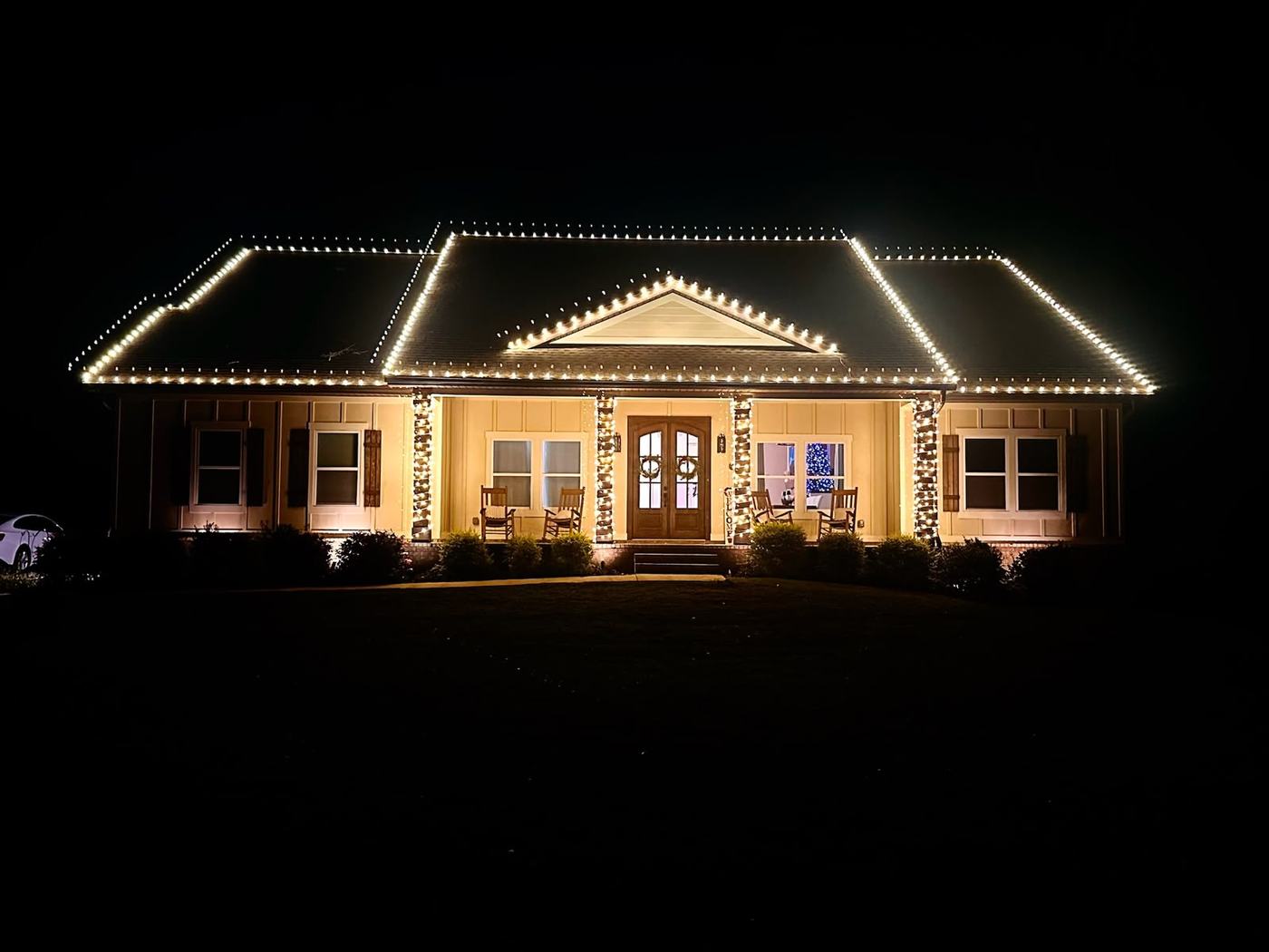 Warm white roofline and porch column lighting on a single-story Windermere home